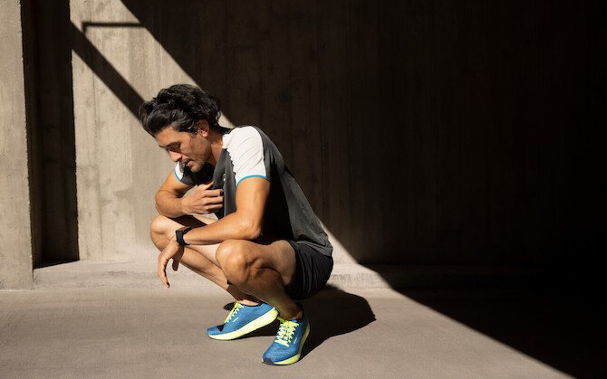 A runner stops to breathe while experiencing a cramp during a run.