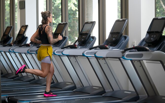 Mujer corriendo en una cinta de correr en el gimnasio