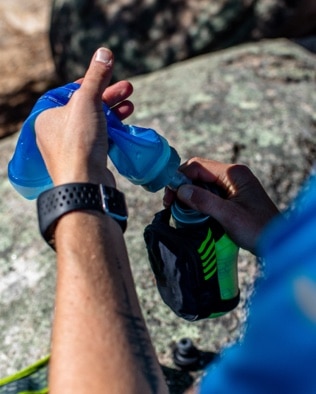 Runner pulling water out of a backpack