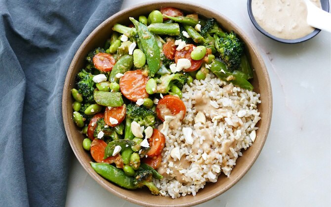 An overhead view of a peanut butter edamame stir-fry bowl with rice.