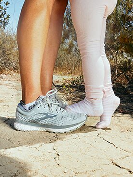 L’enfant d’Anel debout sur ses souliers de course Brooks