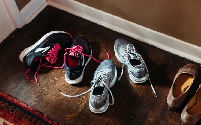Three pairs of shoes near the front door of a house.