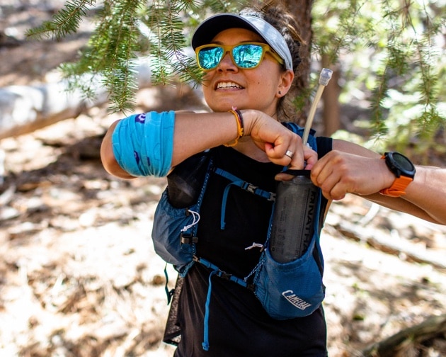 Une femme ajustant son équipement de trail