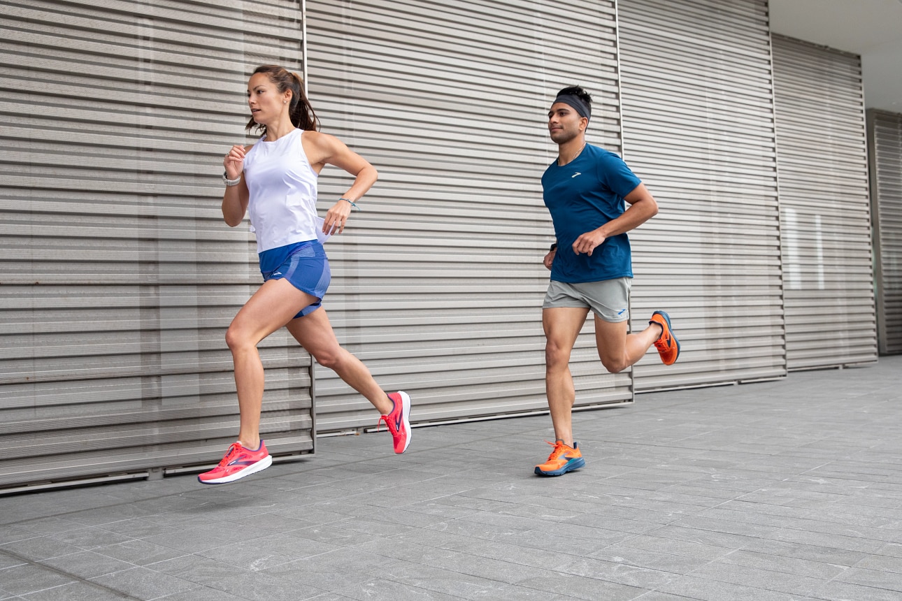 Deux mannequins portant des vêtements et des chaussures Brooks en train de courir