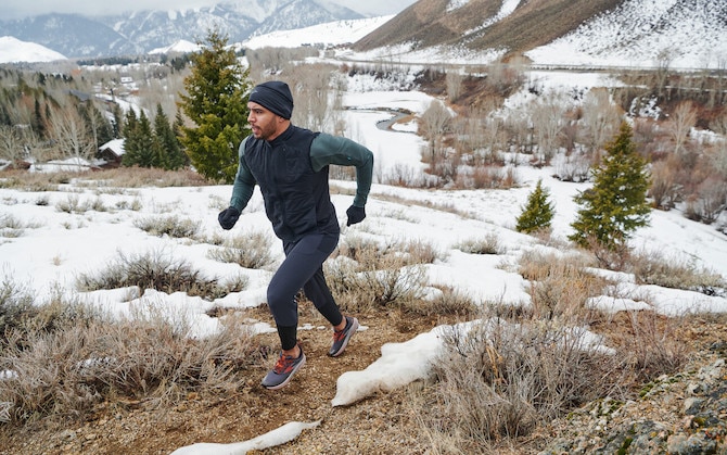 A runner wears a warm hat to protect their ears while on a trail run.