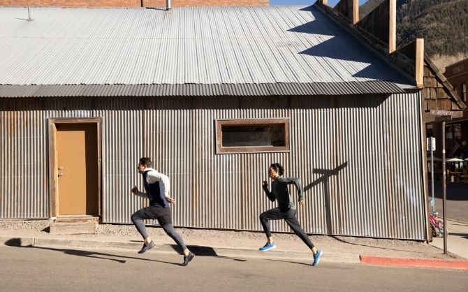 Deux coureurs dans une rue devant un bâtiment