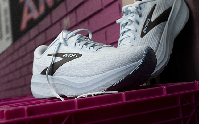 Close up of the Ghost Amp running shoes on a maroon plastic crate and maroon brick in the background