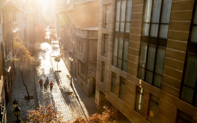 Numerosi runner in lontananza che corrono attraverso le vie della città in una splendida giornata.