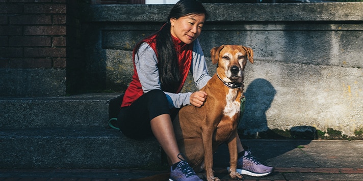 Femme assise avec son chien après la course