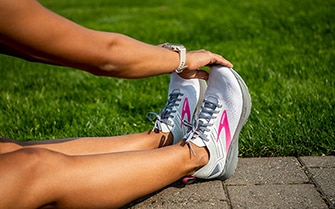 Women reaching for her toes wearing the Ricochet 3 shoes