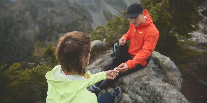 Trail runners resting on top of the mountain while handing out gels