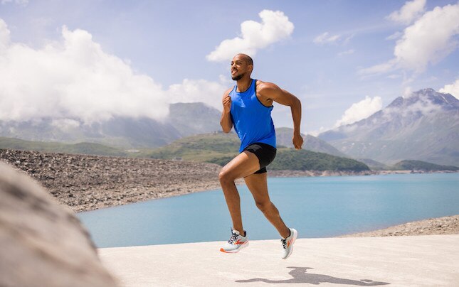 man running with water and mountains in the background