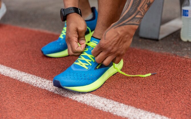 A runner lacing up the Hyperion Tempos