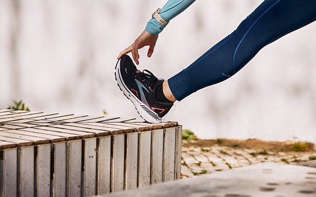 Close up photo of the legs of two runners wearing Brooks Adrenaline GTS shoes with GuideRails technology. 
