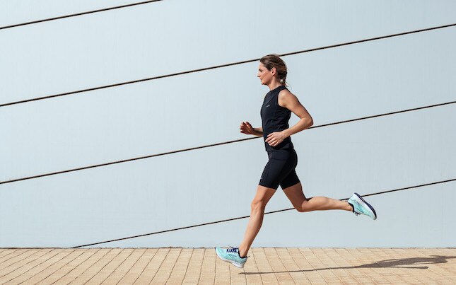 Side view of a runner on a city sidewalk.