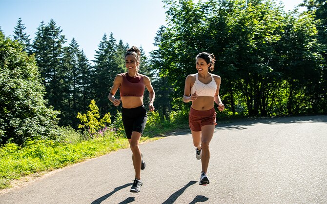 Two women running down a path