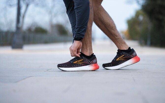 A runner laces up their shoes before a run.