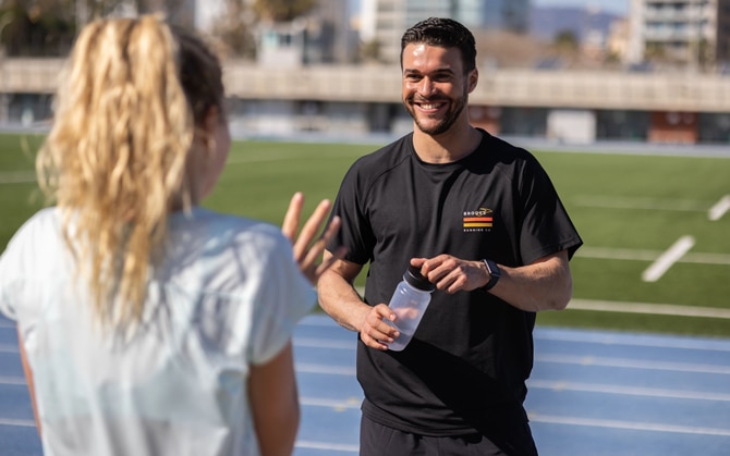 Two runners chatting on a track