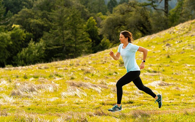 Woman running through mountain meadow