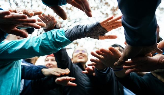 A group of runners holding up their hands.