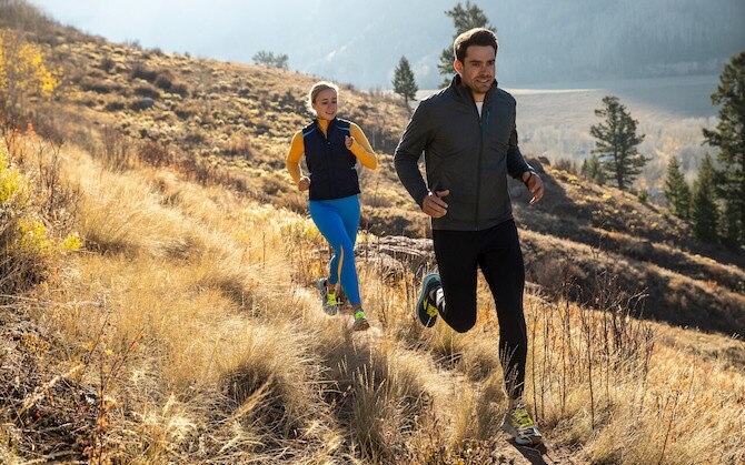 Two runnners on a meadow trail
