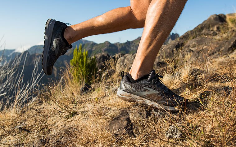 Close-up of runner in the Divide, ascending a grassy mountain slope