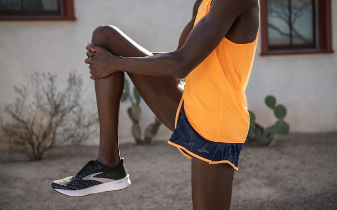 Runner pulling his knee to his chest as a stretch