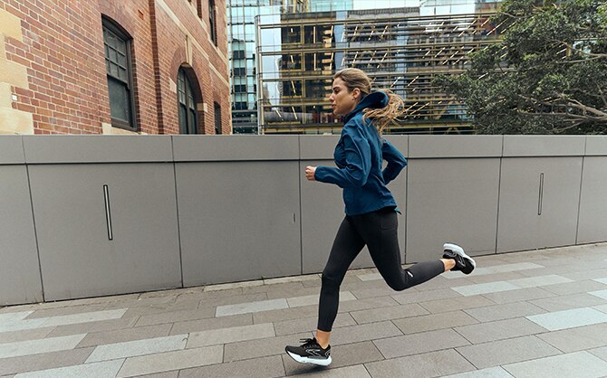 Woman running on a city street wearing Glycerin GTS 21s