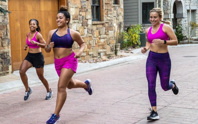 3 runners portant des brassières de running roses et violettes