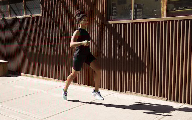 Side view of a runner next to a building