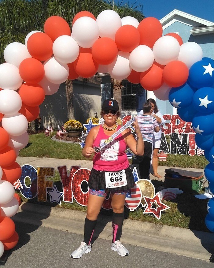 Runner standing beneath a USA balloon arch