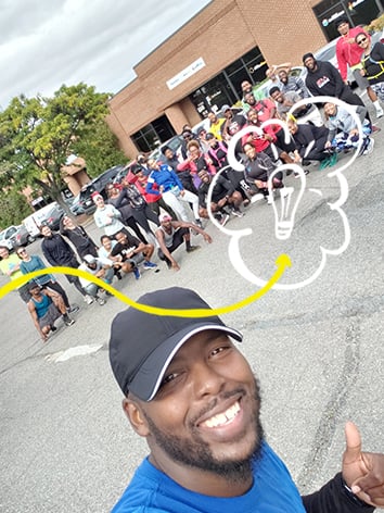 Un homme prend un égoportrait avec un groupe de coureurs