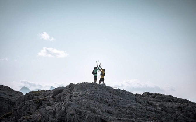 Traillopers die elkaar op een bergtop high-fiven
