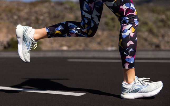 Close-up view of a runner wearing a pair of running shoes with arch support.