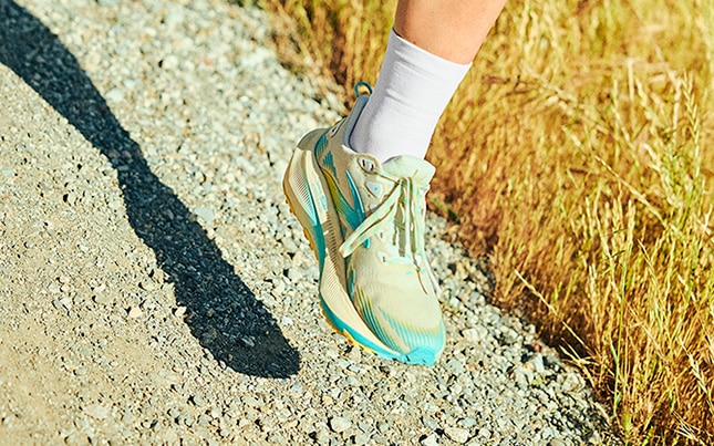 Action shot of someone’s feet mid-air while running on a gravel trail in the Ghost Trail