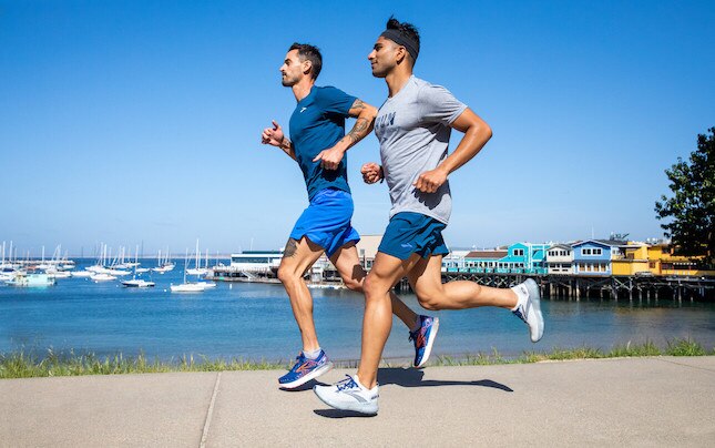 Two men running near the water