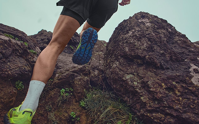 gros plan d’une personne qui court sur un sentier rocheux dans les chaussures de course en sentier Brooks Cascadia 19