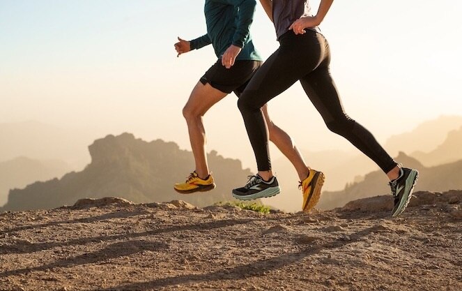 Low-angle shot of two runners on a rocky trail