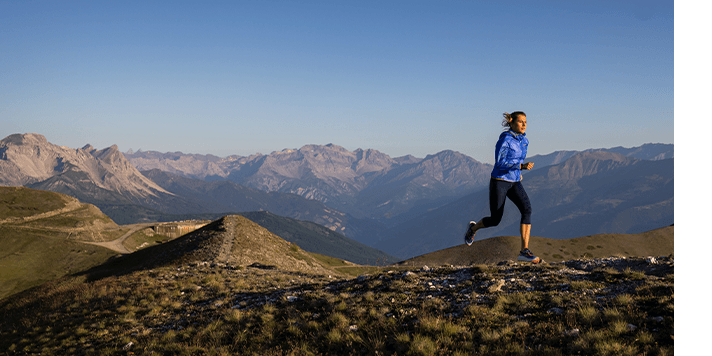 A woman trail running in the mountains