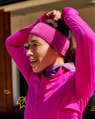 Une femme se met les cheveux en place en portant un serre-tête thermique notch