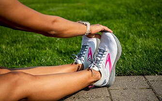 Women reaching for her toes wearing the ricochet 3 shoes