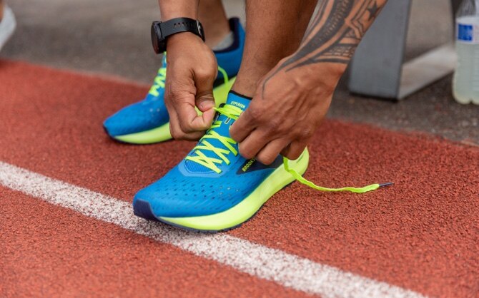 Un runner attachant les lacets de ses Hyperion Tempos