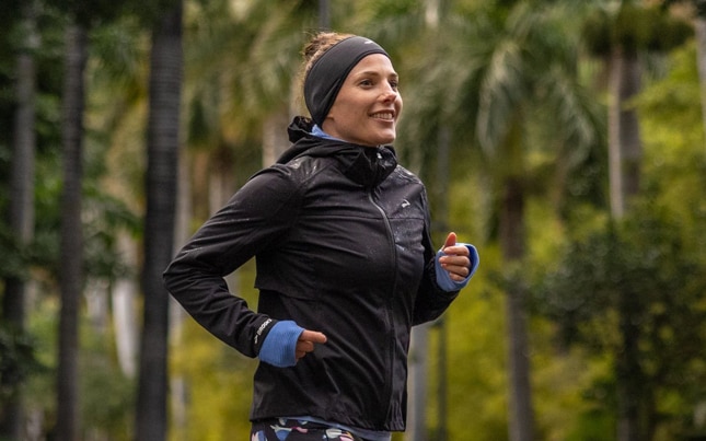 A runner wears a beanie to protect their ears while on a trail run.