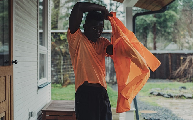 Ein/e Läufer*in zieht sich zur Vorbereitung eine Laufjacke an.