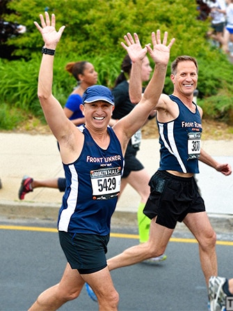 Richard and Zander with their arms in the air mid race. 