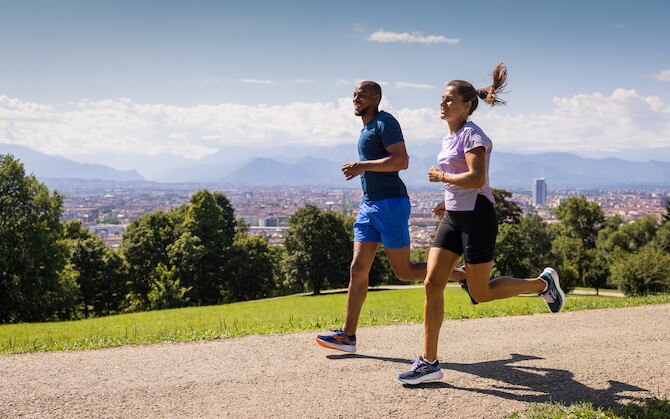 Two runners enjoy a sunny jog on a dirt path.