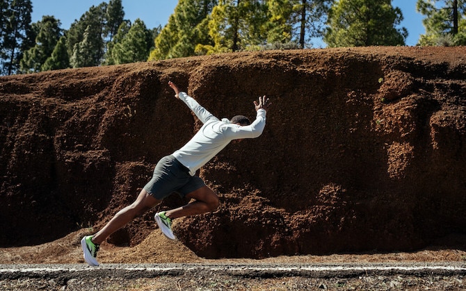 Side view of a runner launching into their stride on a road