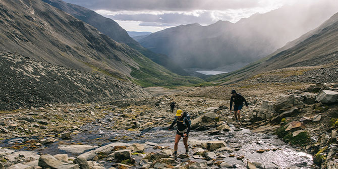 Wanderer/Wanderinnen gehen über Felsen