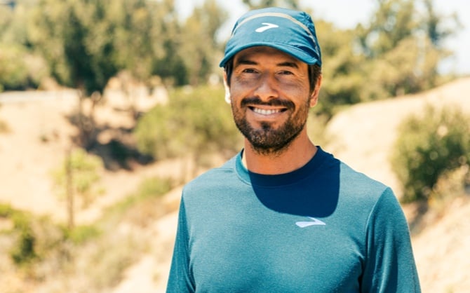 Photo de Tim Senesi portant une chemise et une casquette bleues