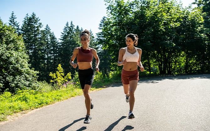 Two women running down a path
